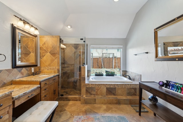 bathroom with lofted ceiling, shower with separate bathtub, and vanity