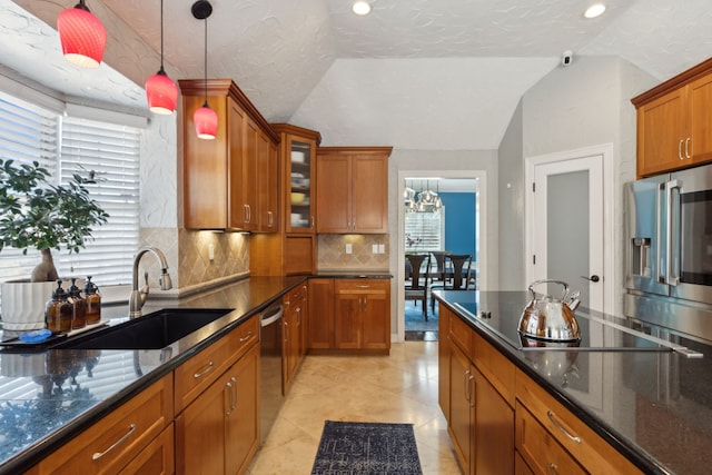 kitchen with appliances with stainless steel finishes, lofted ceiling, sink, backsplash, and hanging light fixtures