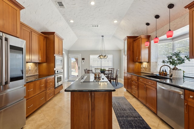 kitchen with pendant lighting, sink, appliances with stainless steel finishes, a kitchen island, and decorative backsplash