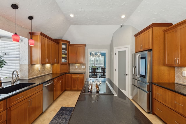 kitchen with sink, tasteful backsplash, vaulted ceiling, hanging light fixtures, and appliances with stainless steel finishes