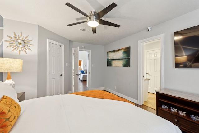 bedroom featuring ensuite bathroom, ceiling fan, and light hardwood / wood-style flooring