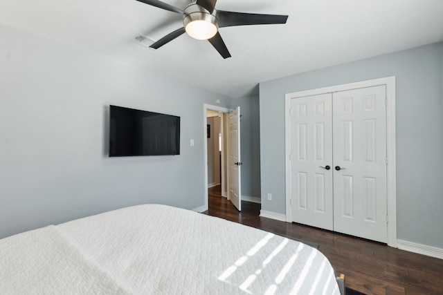 bedroom featuring dark wood-type flooring, a closet, and ceiling fan