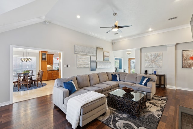 living room featuring a healthy amount of sunlight, dark wood-type flooring, ceiling fan with notable chandelier, and crown molding