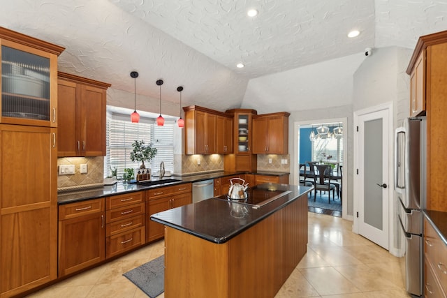 kitchen with vaulted ceiling, pendant lighting, sink, a center island, and stainless steel appliances