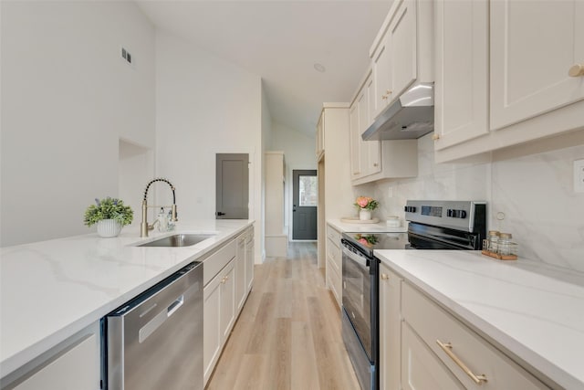 kitchen featuring white cabinetry, stainless steel appliances, light stone countertops, and sink