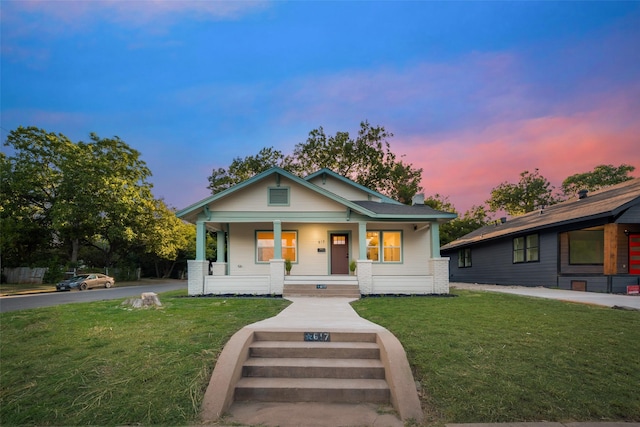 bungalow-style house with a lawn and a porch