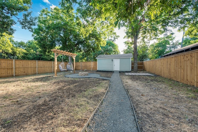 view of yard featuring a storage unit and a fire pit