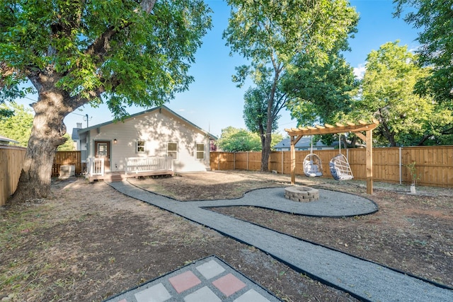 view of yard with a wooden deck, a pergola, and an outdoor fire pit