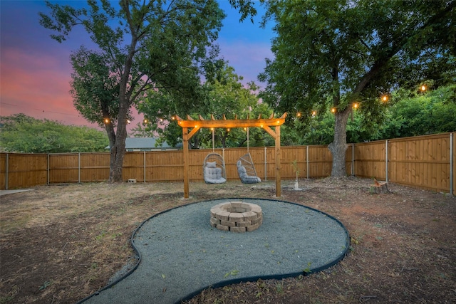 yard at dusk featuring an outdoor fire pit