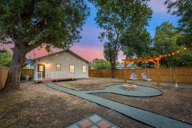 yard at dusk with a wooden deck and an outdoor fire pit