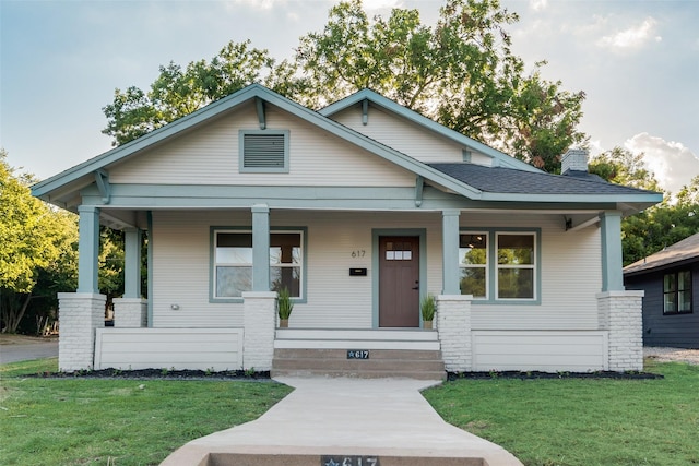 view of front of house with a front yard and covered porch