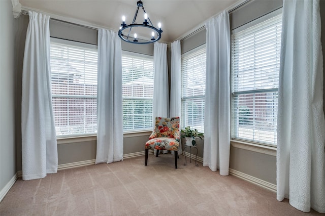 living area with light carpet, a notable chandelier, and plenty of natural light