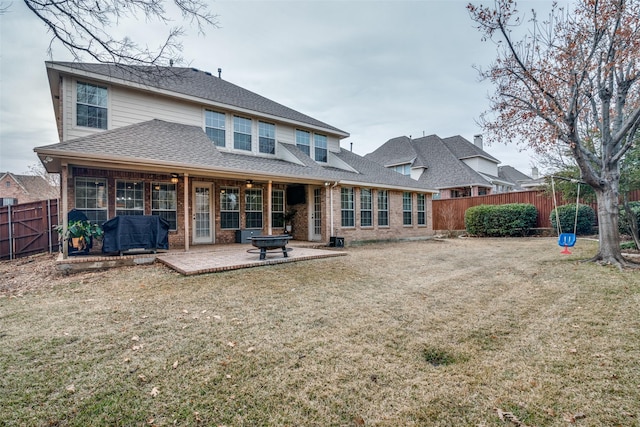 rear view of property featuring a patio area and a lawn