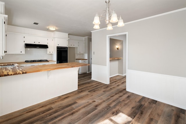 kitchen with white cabinetry, gas cooktop, butcher block countertops, and hanging light fixtures