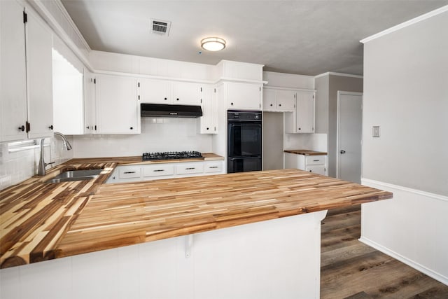 kitchen with wooden counters, black appliances, and white cabinets