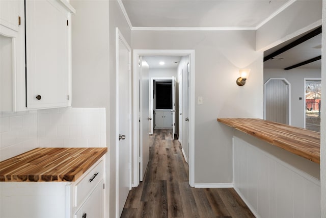 hall with ornamental molding and dark hardwood / wood-style floors