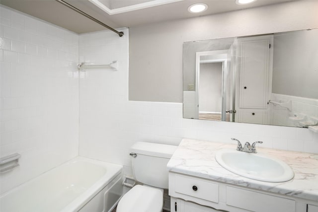 full bathroom with tiled shower / bath combo, vanity, tile walls, and toilet