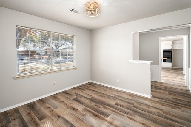 spare room featuring wood-type flooring