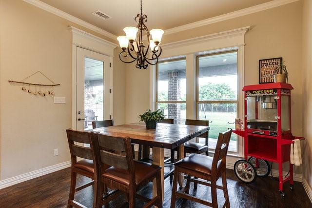 dining room with crown molding, a chandelier, and dark hardwood / wood-style flooring