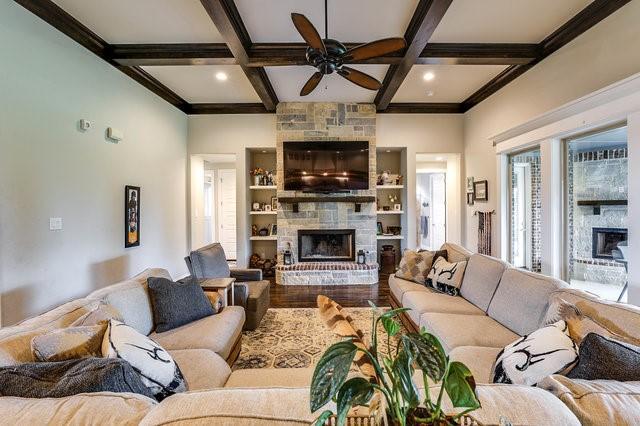 living room with coffered ceiling, hardwood / wood-style flooring, a large fireplace, and beamed ceiling