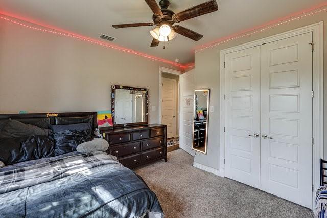 bedroom with light carpet, a closet, and ceiling fan