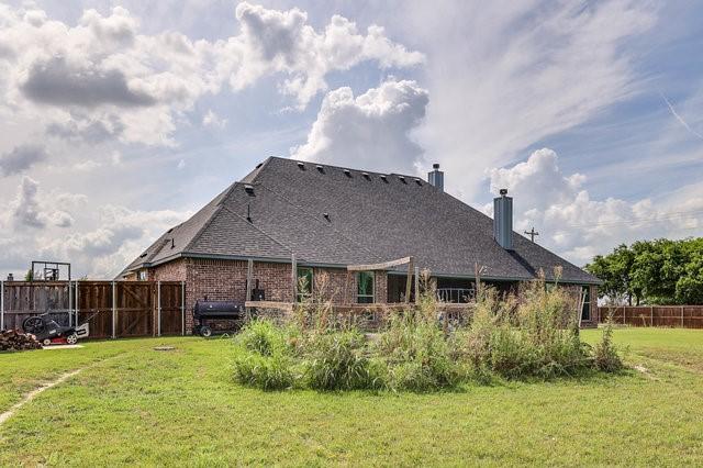 rear view of house featuring a yard