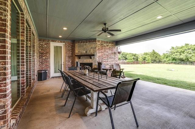 view of patio / terrace featuring exterior fireplace and ceiling fan