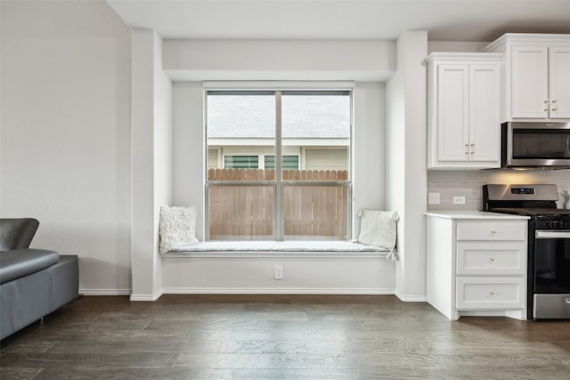 kitchen featuring white cabinetry, decorative backsplash, dark hardwood / wood-style flooring, and appliances with stainless steel finishes