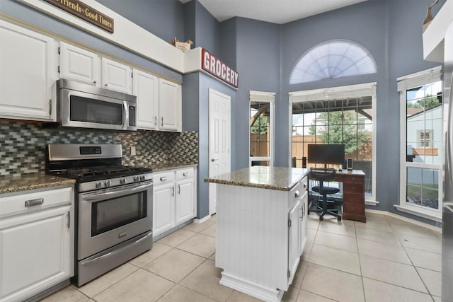 kitchen featuring light tile patterned floors, appliances with stainless steel finishes, and white cabinets