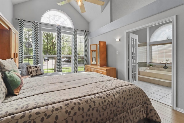 bedroom with a ceiling fan, lofted ceiling, wood finished floors, and ensuite bathroom