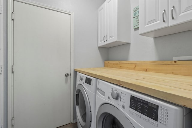 laundry area with washing machine and clothes dryer and cabinet space