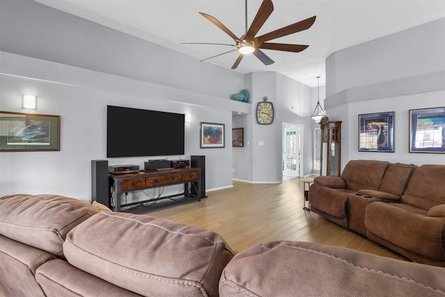 living room with high vaulted ceiling, ceiling fan, baseboards, and wood finished floors