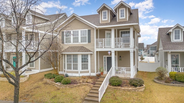 view of front of property with a balcony and a front lawn