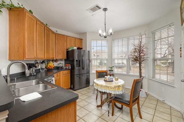 kitchen with sink, a chandelier, hanging light fixtures, light tile patterned floors, and stainless steel fridge