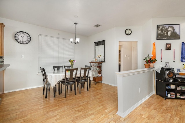 dining room featuring a notable chandelier and light hardwood / wood-style flooring