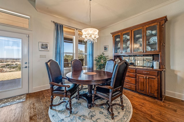 dining space with crown molding, dark wood-type flooring, and a chandelier