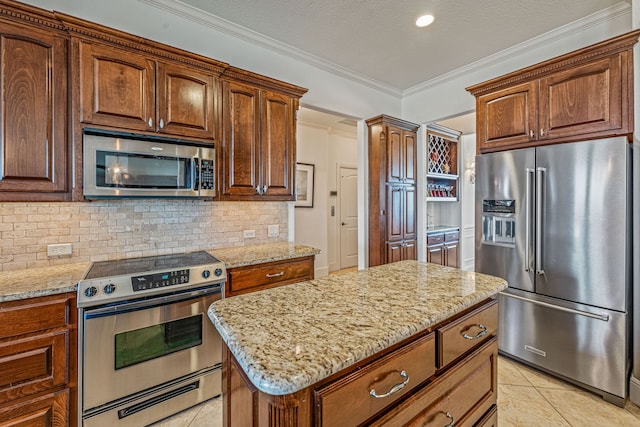 kitchen with crown molding, light stone counters, light tile patterned floors, stainless steel appliances, and decorative backsplash