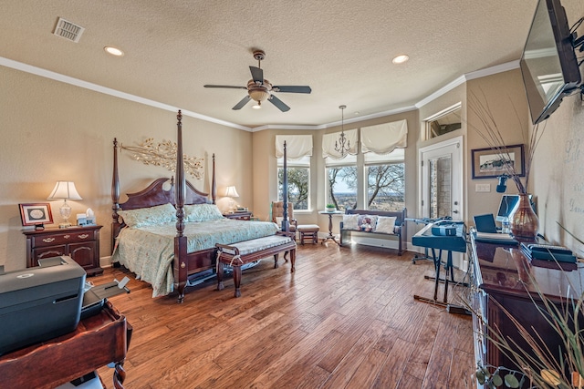 bedroom with hardwood / wood-style flooring, crown molding, ceiling fan, and a textured ceiling