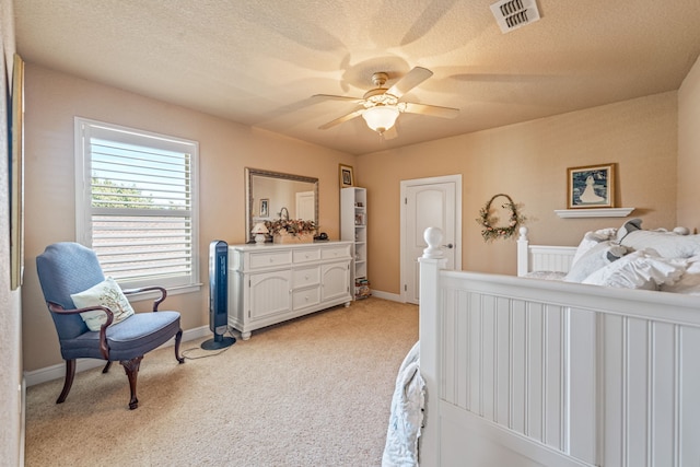 bedroom featuring ceiling fan, light colored carpet, and a textured ceiling