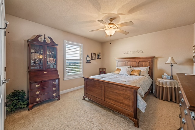 carpeted bedroom with ceiling fan and a textured ceiling