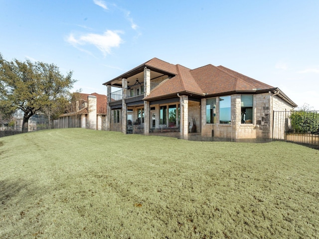 back of property featuring a balcony and a yard