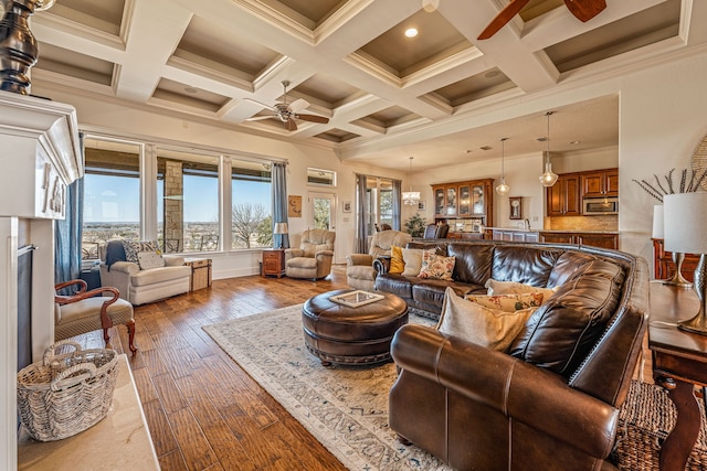 living room featuring hardwood / wood-style flooring, ceiling fan, coffered ceiling, and beam ceiling