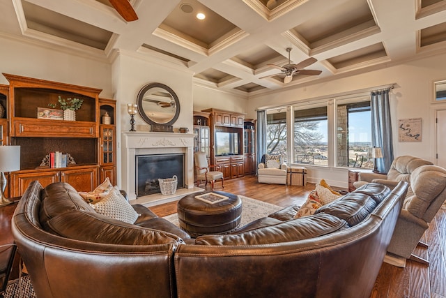 living room featuring coffered ceiling, beamed ceiling, crown molding, hardwood / wood-style flooring, and ceiling fan