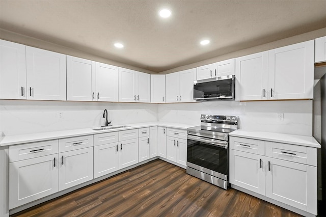 kitchen with sink, white cabinets, dark hardwood / wood-style floors, and stainless steel range with electric stovetop