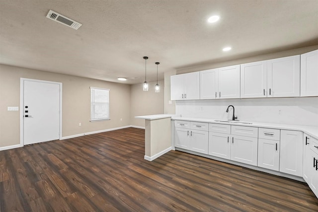 kitchen featuring white cabinetry, decorative light fixtures, and sink