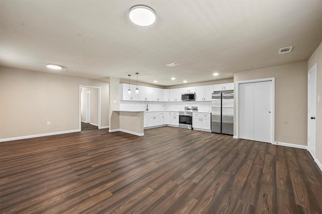 kitchen featuring pendant lighting, white cabinetry, stainless steel appliances, dark hardwood / wood-style flooring, and kitchen peninsula