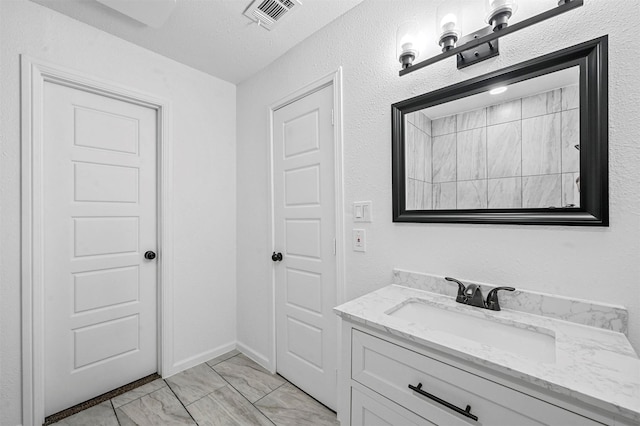 bathroom featuring vanity and a textured ceiling