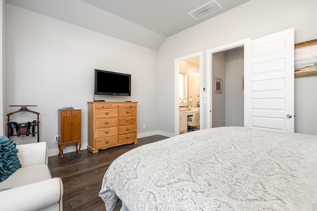 bedroom featuring dark wood-type flooring, ensuite bath, and lofted ceiling