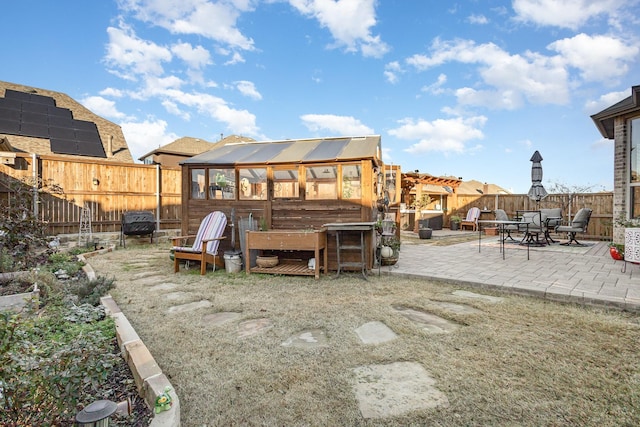 exterior space with an outbuilding, a patio area, and solar panels