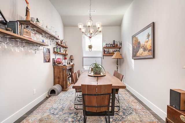 dining area featuring dark hardwood / wood-style floors and a chandelier